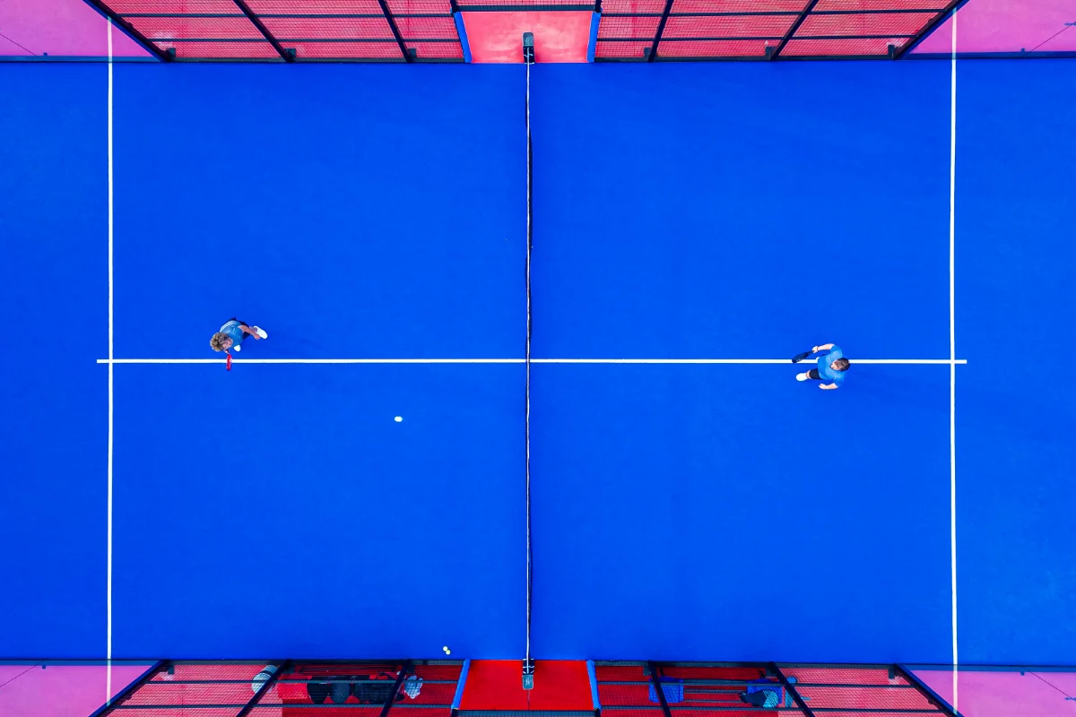 Overhead view of two players competing on an indoor padel court