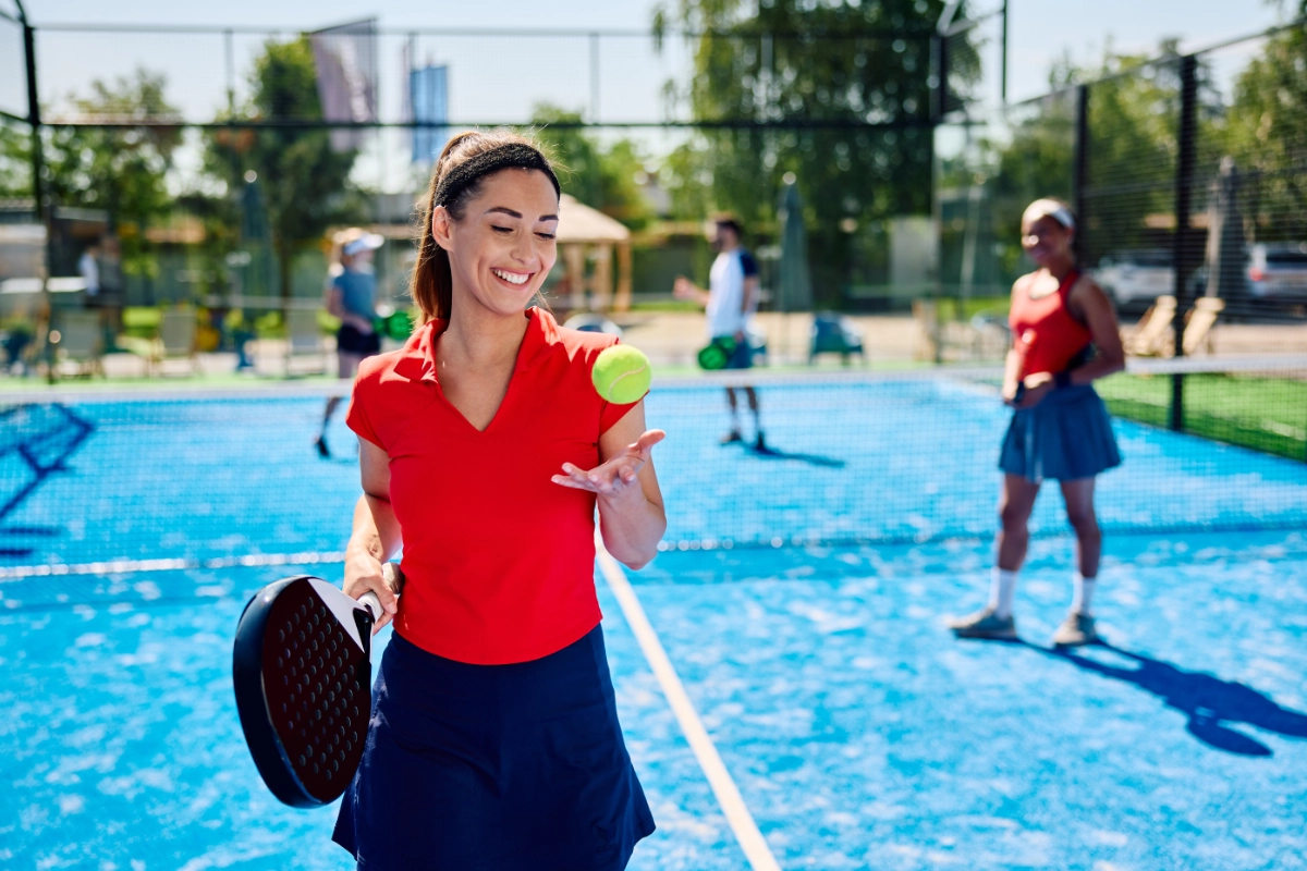 Female player holding a padel racket on court before a match at Court De Padel