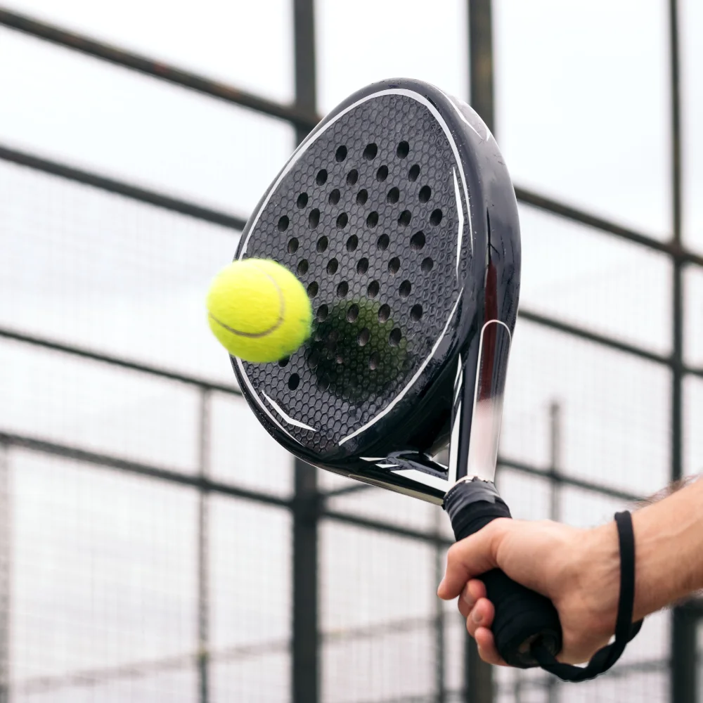 Player hitting a padel ball with a padel racket during a match